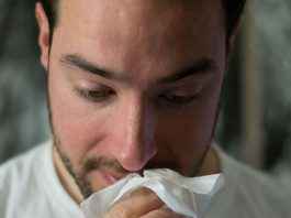 man blowing nose