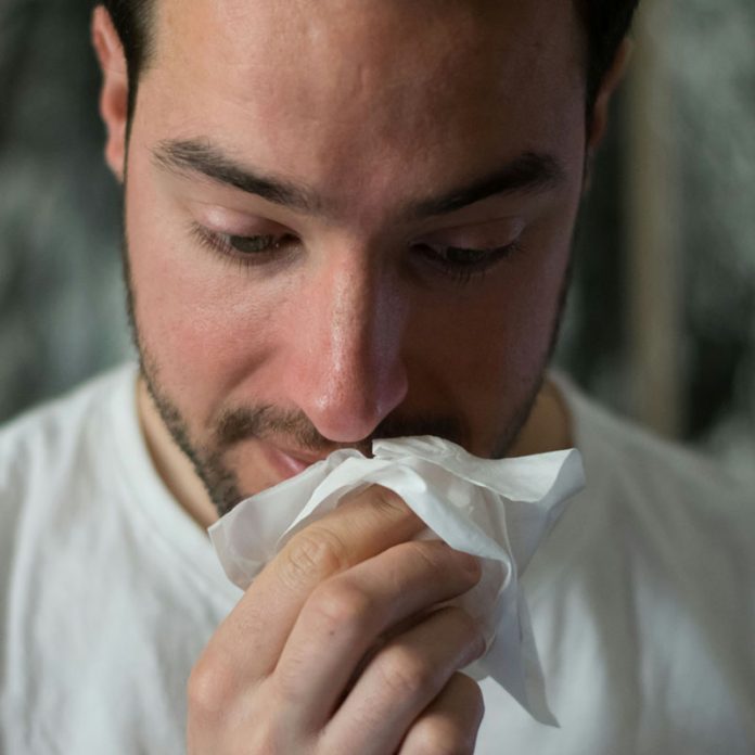 man blowing nose