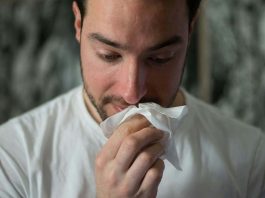 man with tissue and runny nose